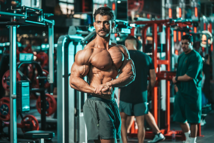 Fitness model posing during a professional sports photography session in Abu Dhabi gym.