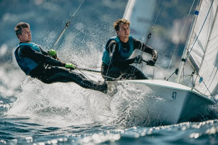 Two sailors racing a dinghy through waves during a UAE sailing competition