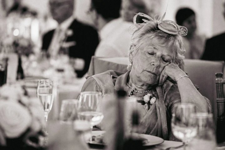 Elderly wedding guest resting at a reception table during an Abu Dhabi wedding celebration.