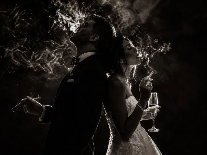 Bride and groom standing back-to-back with smoke illuminated around them during a creative wedding portrait in the UAE.