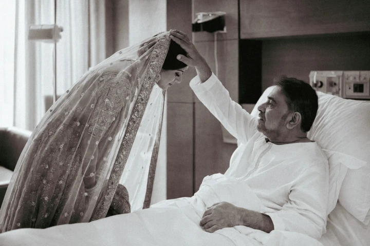 Afghan bride bowing as her father places a hand on her head before her wedding in Dubai