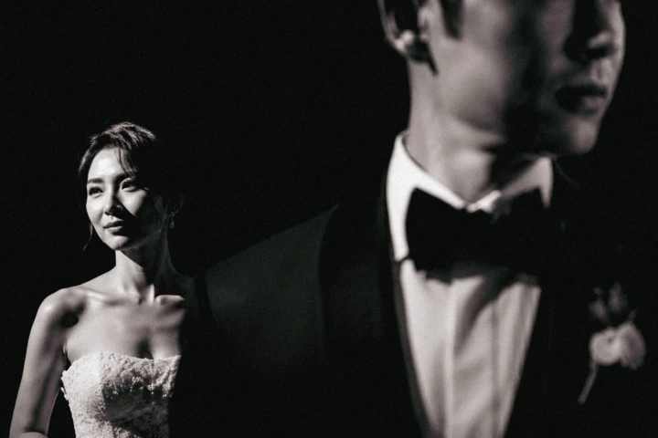 Afghan bride illuminated behind the groom during a dramatic black-and-white wedding portrait in Dubai