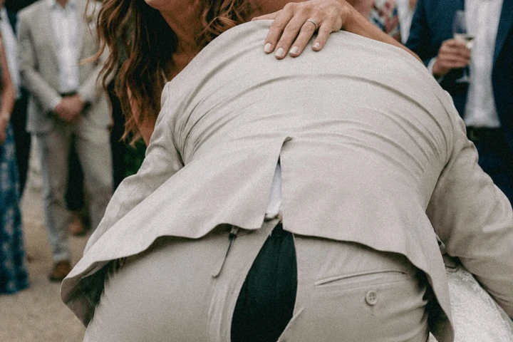 Laughing woman reacting to a male guest’s torn trousers during an outdoor wedding celebration in Dubai.