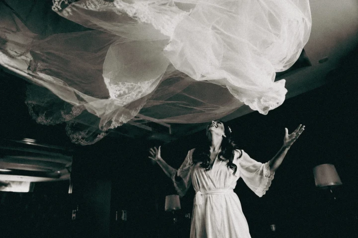 Afghan bride wearing a preparation robe while tossing her wedding dress into the air in Istanbul