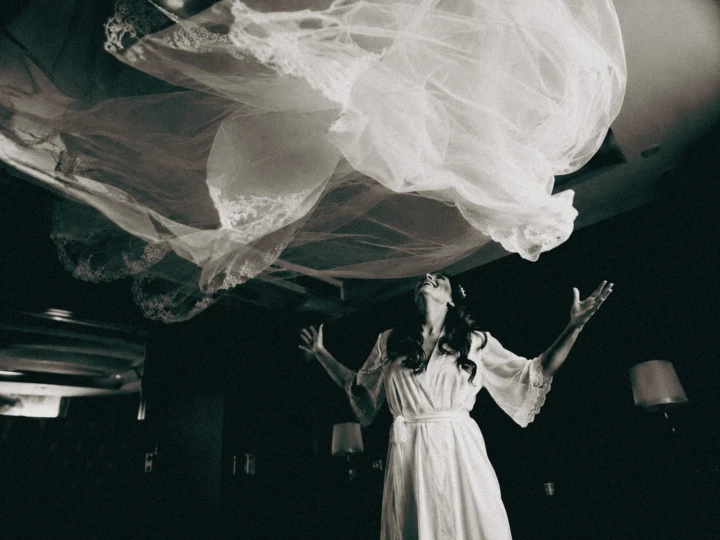 Afghan bride wearing a preparation robe while tossing her wedding dress into the air in Istanbul