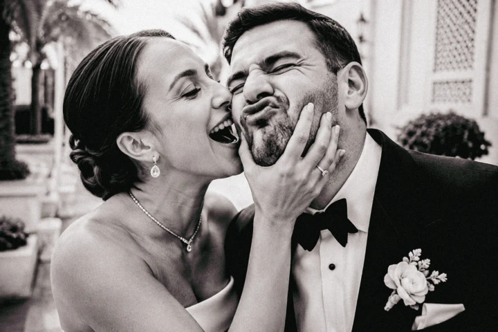 Laughing bride playfully holding the groom’s face during their Abu Dhabi wedding portrait session.