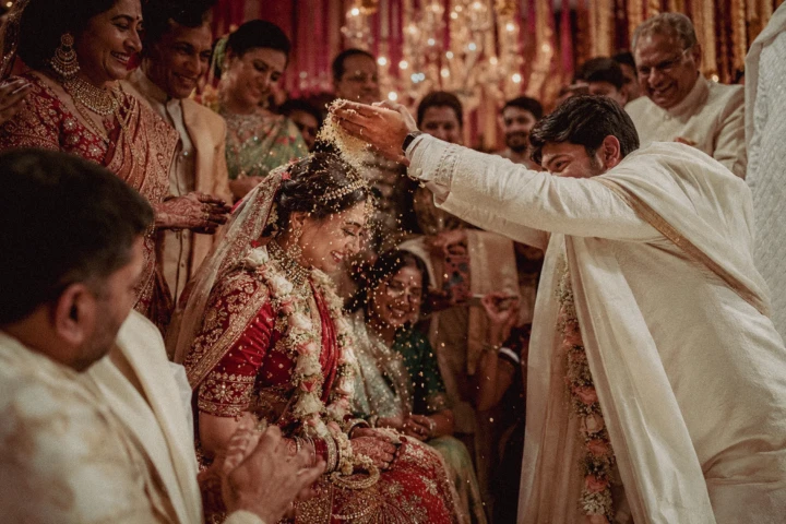 indian wedding photographer , Family member showering an Indian bride with rice during a traditional wedding ceremony in Dubai.
