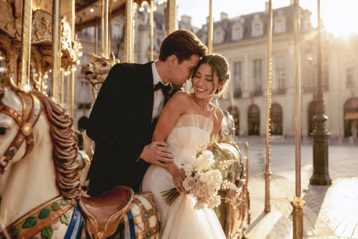 Bride and groom embracing beside a vintage carousel during golden hour at a destination wedding in Turkey.