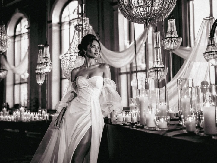 Bride in an elegant wedding dress standing among crystal chandeliers and candles inside a luxury ballroom in Turkey.