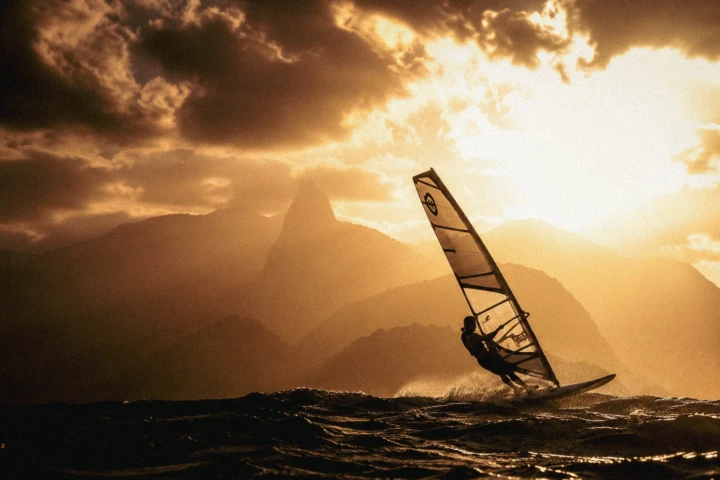 Windsurfer riding through waves at sunset, photographed by a UAE water sports photographer