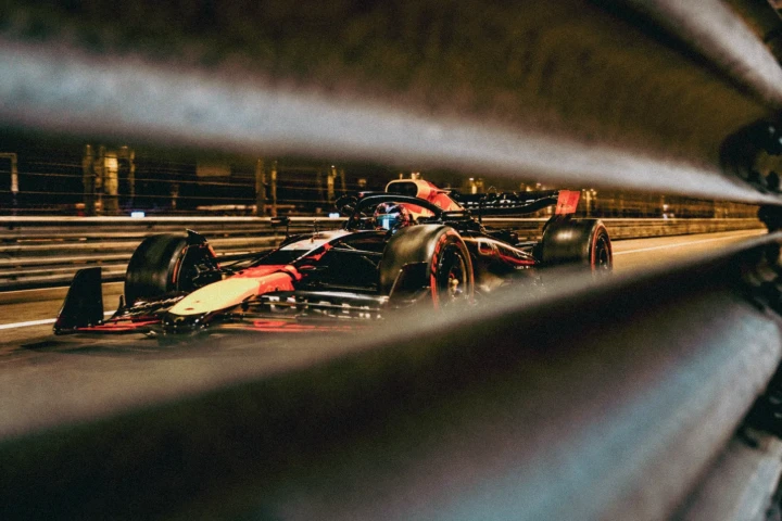 Formula racing car speeding along an illuminated circuit during a night race
