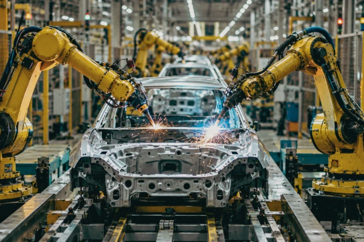 Industrial robotic arms welding a vehicle body on an automated automotive production line inside a manufacturing facility in Dubai, UAE.