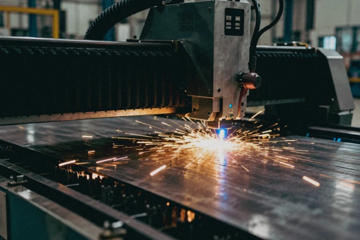 CNC plasma cutting machine producing sparks while cutting a steel sheet inside a metal fabrication facility in Dubai, UAE.
