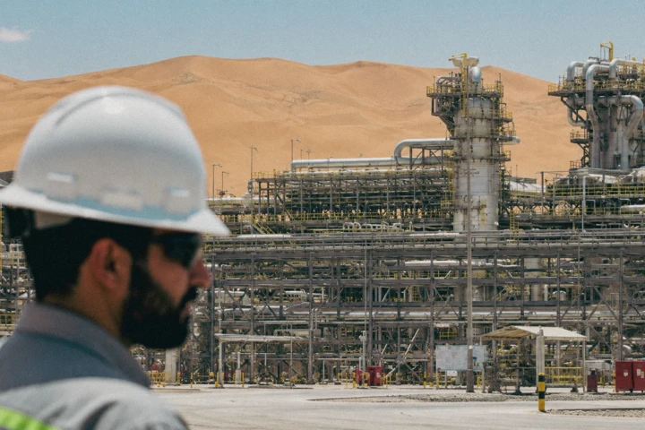 Engineer overlooking a large oil and gas processing facility with pipelines and process towers in a UAE desert industrial environment.